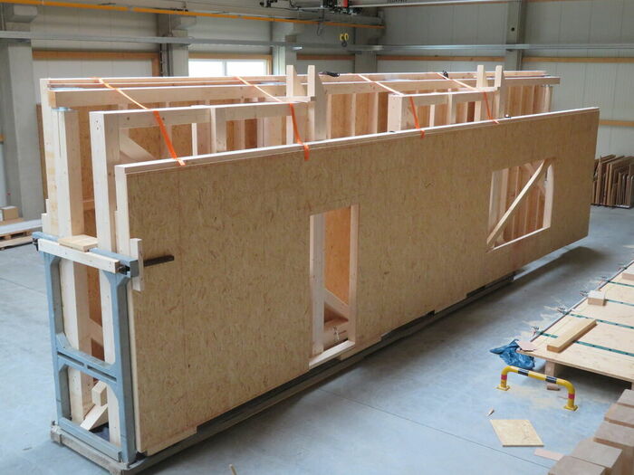 Beladenes Transportgestell mit Holzrahmenbauwänden eines Innenladers Beladenes Transportgestell mit Holzrahmenbauwänden eines Innenladers…