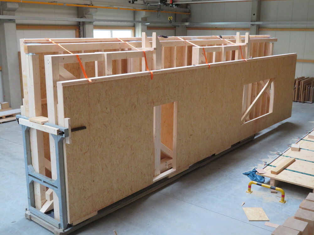 Beladenes Transportgestell mit Holzrahmenbauwänden eines Innenladers Beladenes Transportgestell mit Holzrahmenbauwänden eines Innenladers…