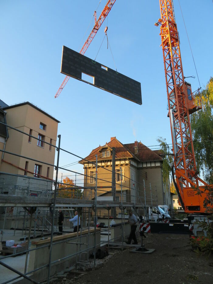 Heben voll elemtierter Holzrahmenbauwände Heben voll elemtierter Holzrahmenbauwände ohne Fassadenbekleidung…